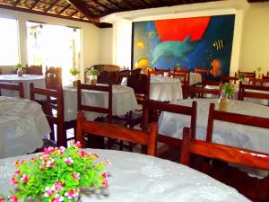 un restaurante con mesas y sillas y una pintura de un tiburón en Pousada Porto Feliz, en Porto Seguro