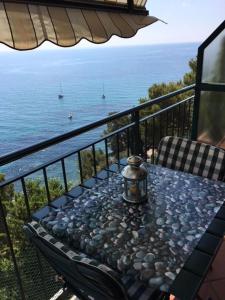 a table on a balcony with a view of the ocean at Appartamento Villa Panorama in Mortola Inferiore