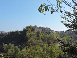 a building on top of a hill with trees at Locanda Montecarlo in Lesegno