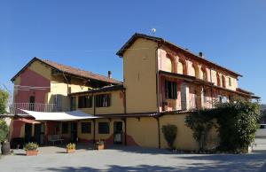 un antiguo edificio con un paraguas blanco delante de él en Locanda Montecarlo, en Lesegno