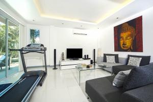 a living room with a couch and a tv at VILLA CHELONI 2 BEDROOMS in Kamala Beach