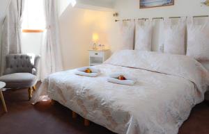 a bedroom with a bed with two bowls of fruit on it at Logis Hôtel et Restaurant du Dauphin in Sées