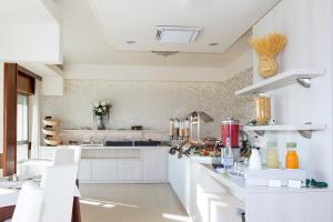 a kitchen with white counters and white cabinets at Hotel Life in Rimini