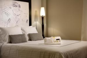 een slaapkamer met een bed met witte lakens en kussens bij ALTIUS LODGE by K&K in Athene
