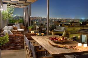 a table with a bowl of fruit on a balcony at ALTIUS LODGE by K&K in Athens