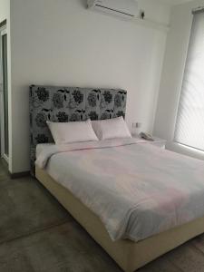 a bedroom with a large bed with a black and white headboard at The Big House in Colombo