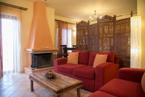 リメニにあるSophia Limeni Viewのリビングルーム(赤いソファ、暖炉付)
