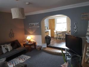 a living room with a couch and a tv at Sea breeze holiday apartment in Weymouth