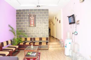 salon z kanapą i ceglaną ścianą w obiekcie SGS Residency w mieście Tirupati