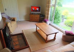 a living room with a coffee table and a tv at Ardno Cottage by Loch Fyne in Cairndow