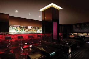 a room with a bar with red chairs and tables at Luxury Suites at Palms Place in Las Vegas