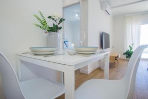 a white table with two white chairs and a tv at Flower Beach Suite 25 in Playa Honda