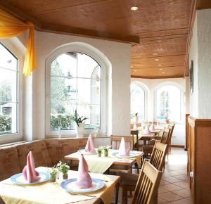un restaurante con mesas y sillas con servilletas rosas. en Hotel Restaurant Daute en Iserlohn