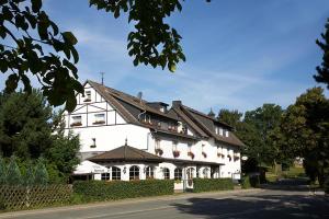 a large white building with a black roof at Hotel Restaurant Daute in Iserlohn
