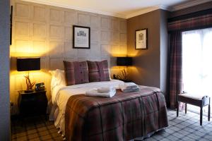 a hotel room with a bed with two towels on it at Forrester Park Resort in Dunfermline