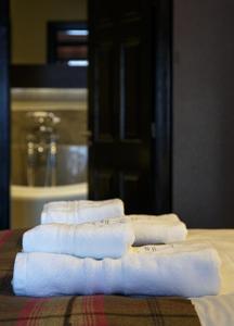 4 asciugamani sono impilati su un tavolo con una stanza di Forrester Park Resort a Dunfermline