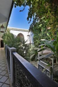 een balkon met een hek en bomen en een gebouw bij Riad Dar El Assafir in Marrakesh
