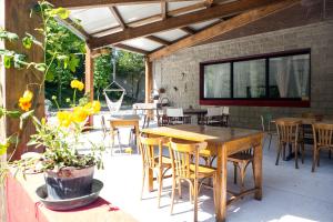 an outdoor patio with wooden tables and chairs at Ostello Valtrebbia in Marsaglia