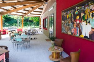 a restaurant with a red wall with tables and chairs at Ostello Valtrebbia in Marsaglia