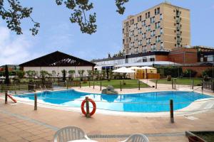 a large swimming pool in front of a building at Rey Sancho Palencia in Palencia