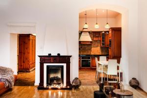 a living room with a fireplace and a kitchen at Art Apartments Ruzova in Prague