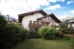 a white house with a brown roof at Alpine Dream Apartments in Bormio