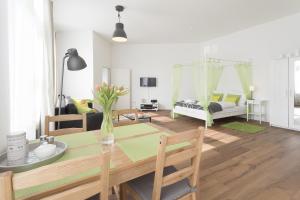 ベルリンにあるStudio Apartment Niemetzstr 51のリビングルーム(ダイニングテーブル付)、ベッドルーム1室が備わります。