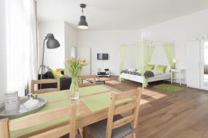 ein Wohnzimmer mit einem Esstisch und ein Schlafzimmer in der Unterkunft Studio Apartment Niemetzstr 51 in Berlin