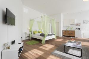 a white living room with a bed and a tv at Studio Apartment Niemetzstr 51 in Berlin