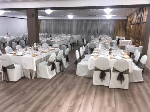 a banquet hall with white tables and white chairs at Rey Sancho Palencia in Palencia