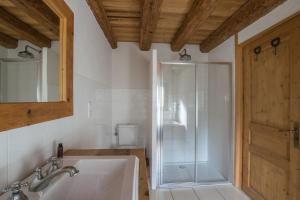 a bathroom with a shower and a sink and a tub at La Ferme du Château in La Chapelle-dʼAbondance