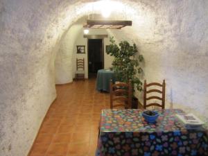 a dining room with a table and a table and chairs at Cuevas el Balcón de Orce in Orce