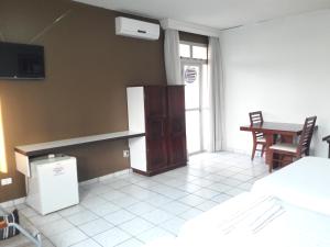 a kitchen with a refrigerator and a table at Schalom Hotel in Imperatriz