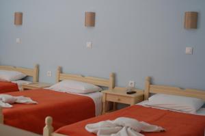 two beds sitting next to each other in a room at Hotel Paros in Parikia