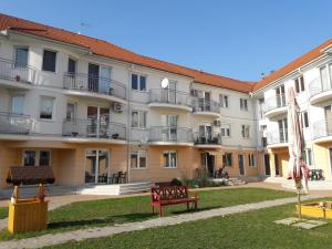 eine Reihe von Apartmentgebäuden mit einer roten Bank davor in der Unterkunft Happy apartman in Hajdúszoboszló