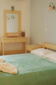 a bedroom with two beds and a dresser with a mirror at Hotel Paros in Parikia