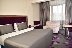 a hotel room with a large bed and a chair at Hande Hotel in Mustafakemalpaşa +139 photos