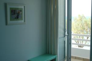 a room with a green bench next to a window at Hotel Paros in Parikia