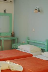 a room with two beds and a table with a mirror at Hotel Paros in Parikia