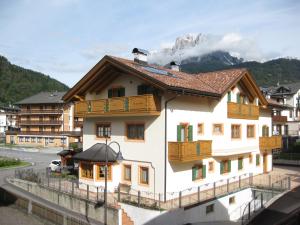 a white building with a mountain in the background at Affittacamere Villa Sole in Fiera di Primiero