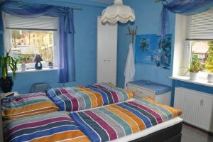 2 Betten in einem Schlafzimmer mit blauen Wänden und Fenstern in der Unterkunft Haus "Tabor" in Bad Schlema