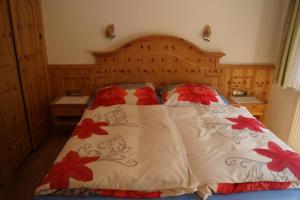 トゥクスにあるHaus Bergheimatのベッドルーム1室(赤い花のベッド1台付)