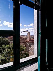 an open window with a view of a building at Hotel Trindade Coelho in Mogadouro