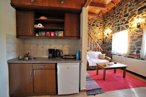 a kitchen with a sink and a table in a room at Aroma Elatis in Palaios Agios Athanasios