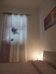 ein Schlafzimmer mit einem Bett mit einem Vorhang und einer Lampe in der Unterkunft Felicity5terre in La Spezia
