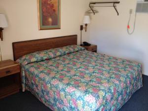 a bedroom with a bed with a colorful comforter at Greencastle Inn in Greencastle