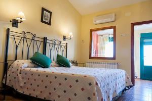 a bedroom with a bed with green pillows at Apartamentos Los Panchos in Ruidera
