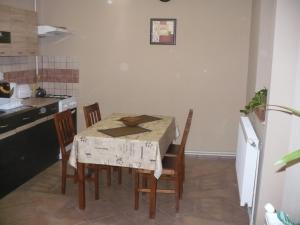 a kitchen with a table and chairs in a kitchen at Kis Rigó vendégház in Salgótarján