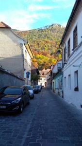 a street with cars parked on the side of a building at Mama Brasov in Braşov