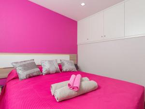 1 dormitorio rosa con 1 cama rosa y 2 toallas en Casa Silva, en Calheta